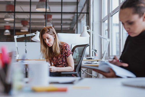 Young woman busy working at her desk