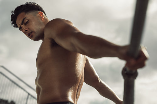 Sportsman stretching by a railing