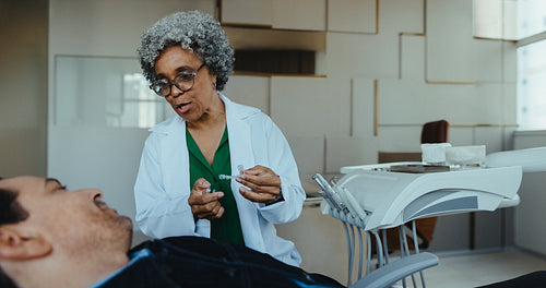 Senior patient consults with female dentist about aligners in modern clinic