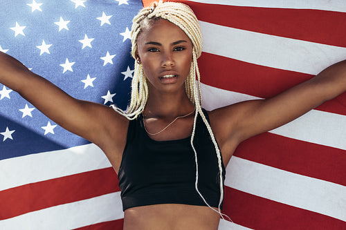 Female athlete holding american flag behind her