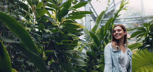 Smiling female working in greenhouse