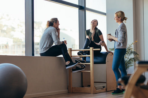 Fitness women relaxing after workout in a gym