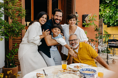 Happy latin family gathering during an outdoor barbecue meal on a sunny day