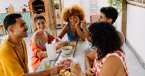 A group of five friends enjoying snacks and drinks on a Saturday afternoon