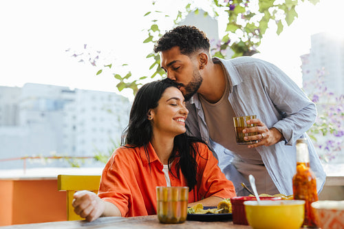 Loving couple enjoying a relaxed meal together on a sunny balcony