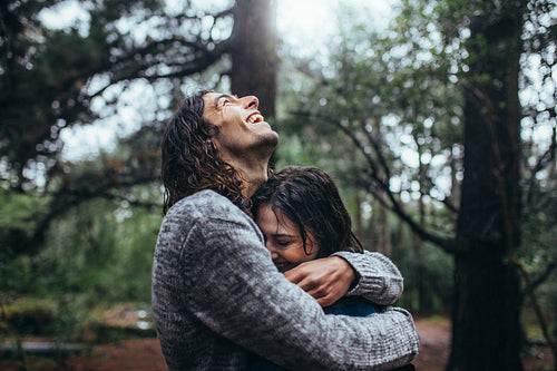 Couple in love embracing in the park under rain