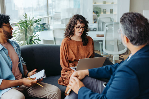Business professionals brainstorming ideas for a creative project in a modern office