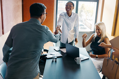 Diverse colleagues greeting during a productive team meeting in a bright office