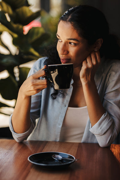 Woman sitting at cafe having coffee.