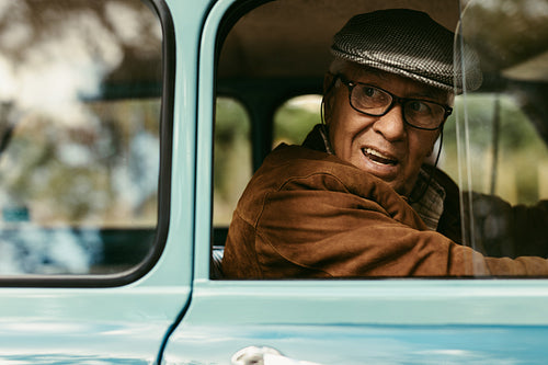 Elderly man driving a vintage car