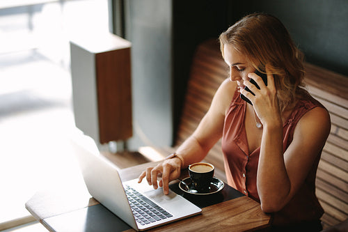 Woman working on a laptop computer at a coffee shop