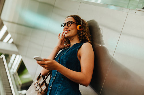 Commuting woman chats through headphones in an underground metro station