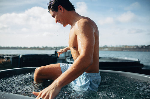 Man exits invigorating ice bath in outdoor recovery session
