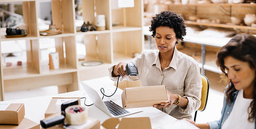 Online store owner scanning the barcode of a package box in a warehouse