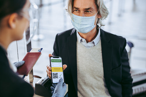 Businessman shows his vaccination passport to ground attendant