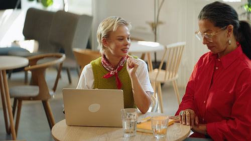 Coworkers collaborate in a business meeting around a table in a cafe office