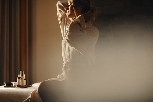 Woman enjoying a relaxing massage at spa with luxury skincare products