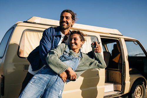 Playful moment: Couple laughs together beside their camper van