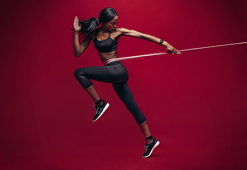 Sporty woman exercising with resistance band 