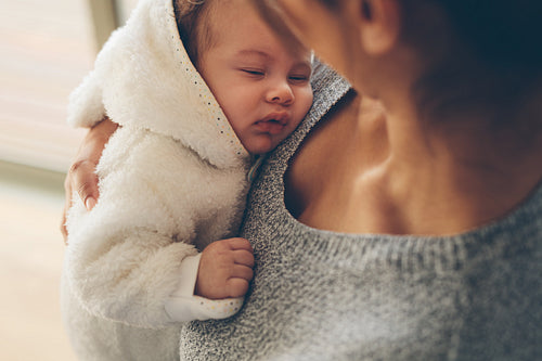 Cute little boy sleeping in his mother's arms