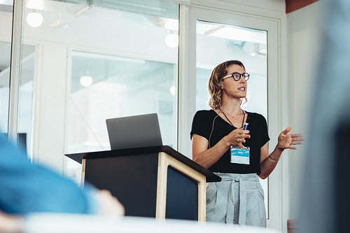 Businesswoman public speaking behind the podium