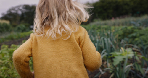 Adorable little girl running towards her mom in a garden