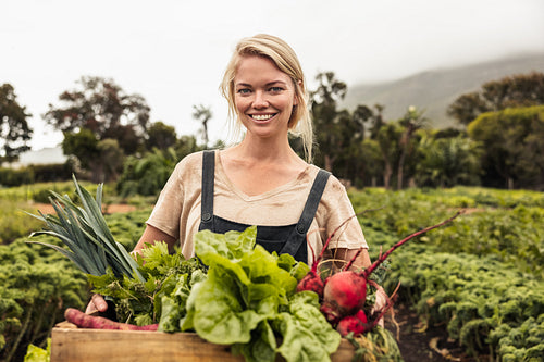 Vegetable farmer smiling cheerfully after harvest