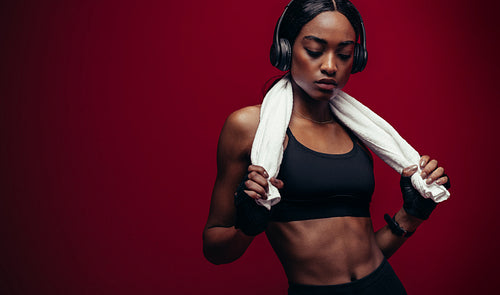 African female athlete listening music after workout