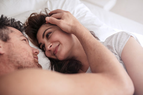 Romantic couple lying together on bed