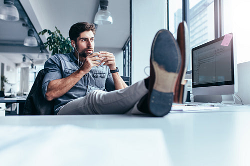 Young man drinking coffee during break in office