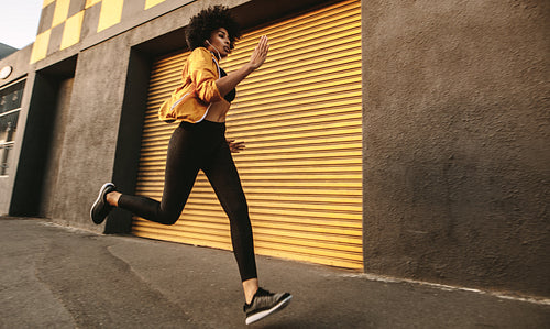 Sporty young woman sprinting outdoors