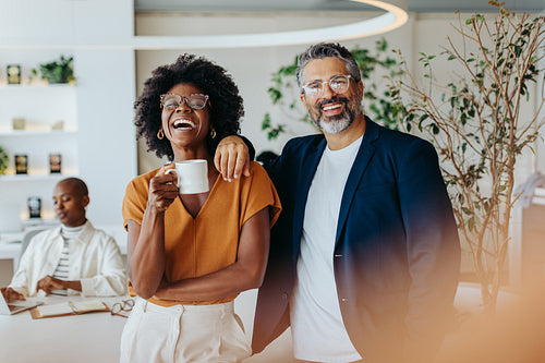 Successful business team standing together in office, smiling and looking at camera