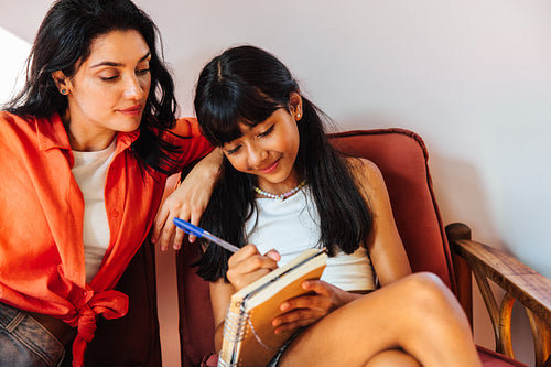 Mother and daughter sharing quality time with writing activities at home