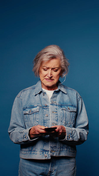 Concerned senior woman using smartphone, confused by technology, frustrated with mobile device