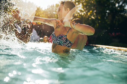 Woman having fun with friends in swimming pool