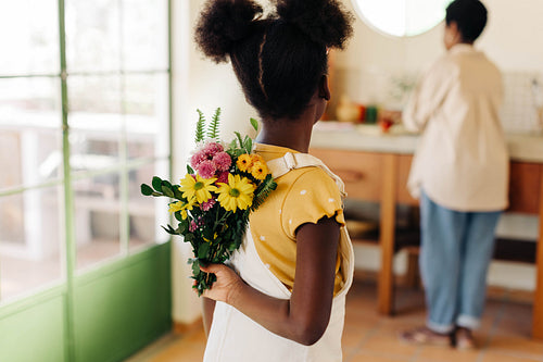 Daughter surprising mom with flowers in the kitchen