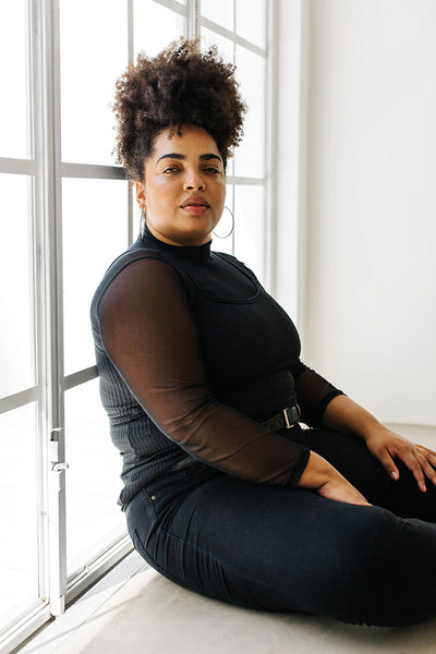 Fashionable woman sitting by window