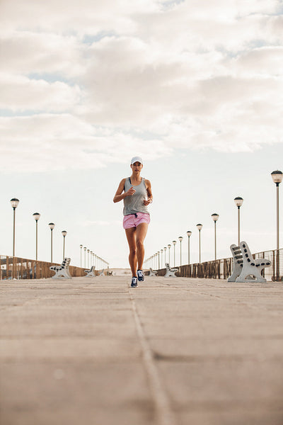 Young woman running on the sea side promenade