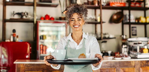 Happy cafe owner giving a customer their order