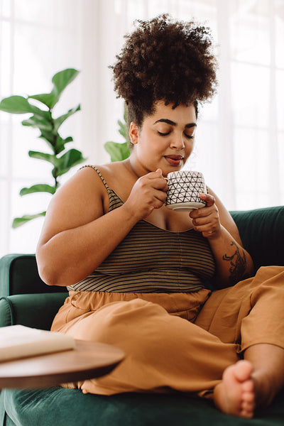 Woman sitting on couch having coffee