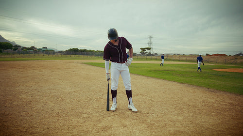 Baseball player stands ready on the field, bat in hand