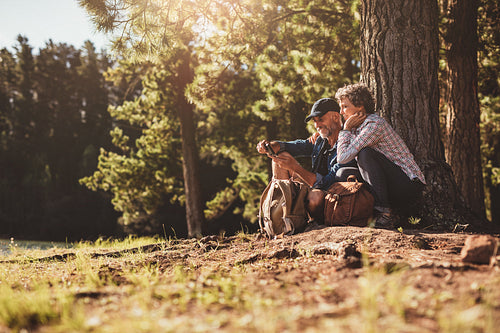 Smiling mature couple looking for directions with compass