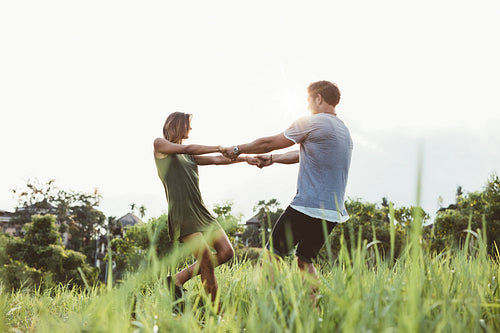 Young couple dancing in a field of tall grass