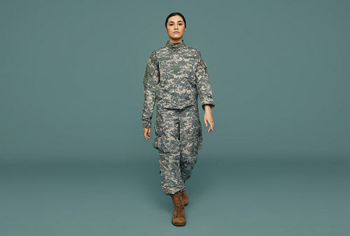 Young American servicewoman marching in a studio