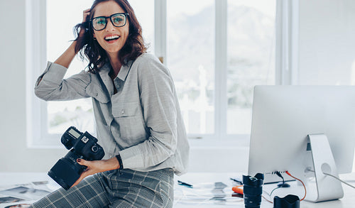 Smiling female photographer in office