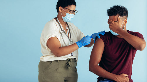 Scared man getting a vaccine shot