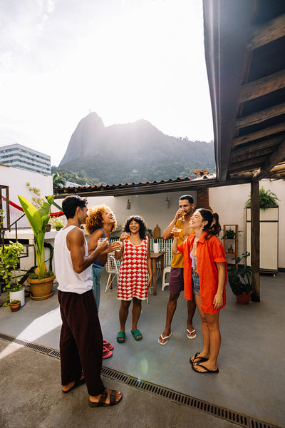 Group of friends socializing on terrace with Corcovado hill in background
