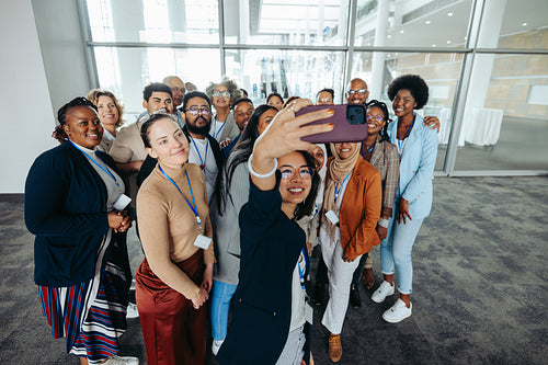 Corporate team of diverse colleagues taking a group selfie at the office