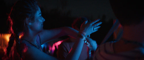 Serene young woman dancing at night at a music festival