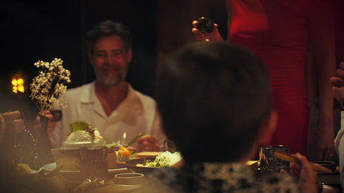 Families and couples enjoy a serene evening stroll on a luxurious resort pier at dusk